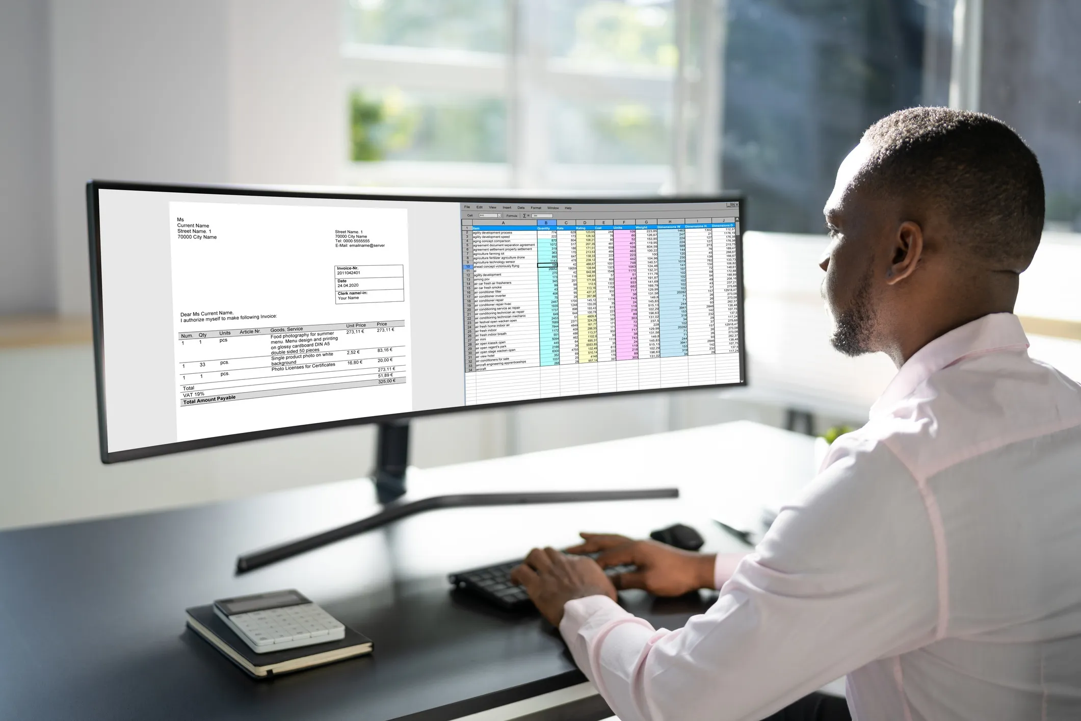 Man in light pink shirt working at desk with large curved monitor showing invoice and spreadsheet data.