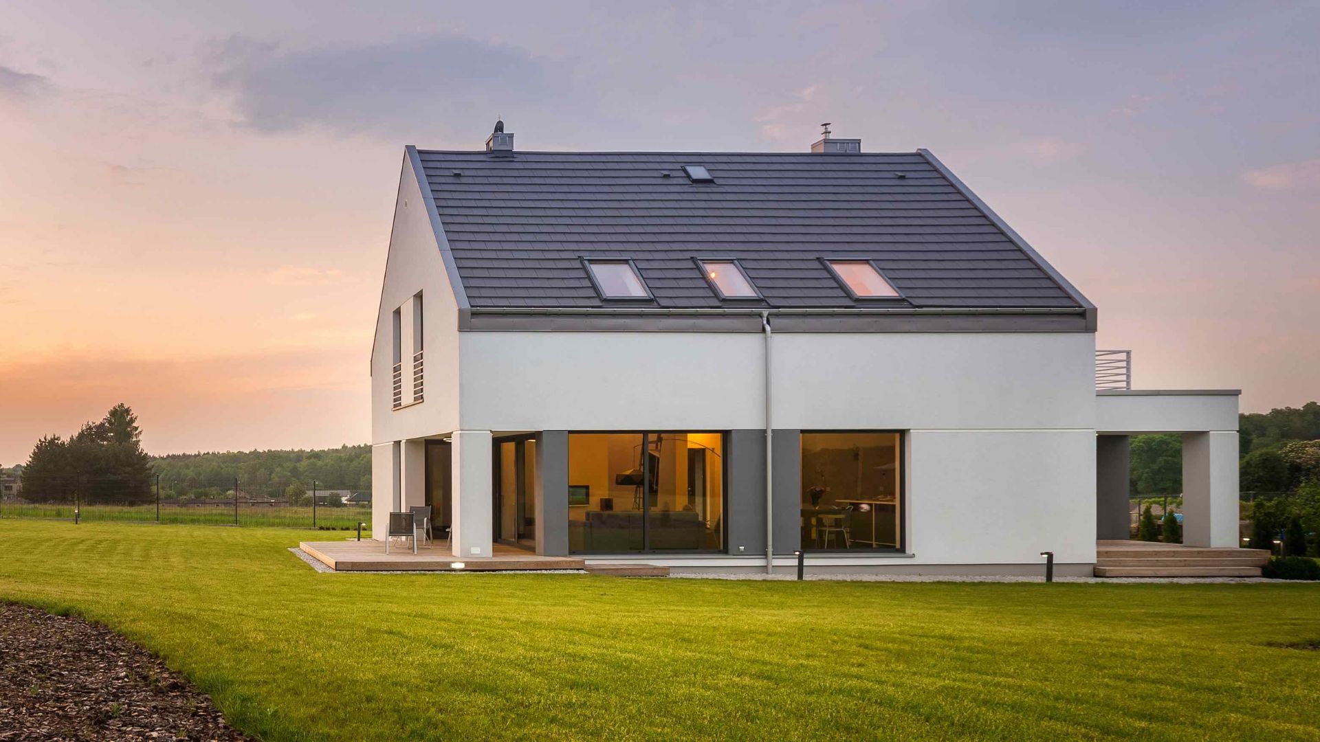 Modernes Einfamilienhaus in Abendstimmung mit weitläufigem Garten