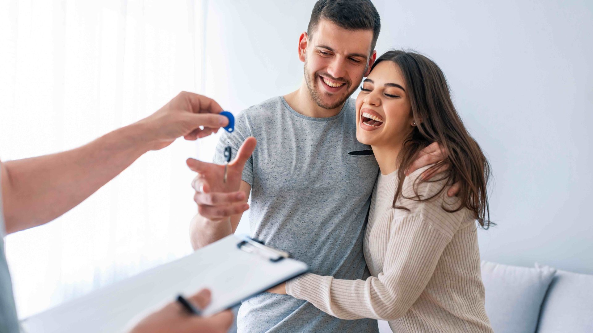 Fröhliches Paar erhält Schlüssel für neues Zuhause