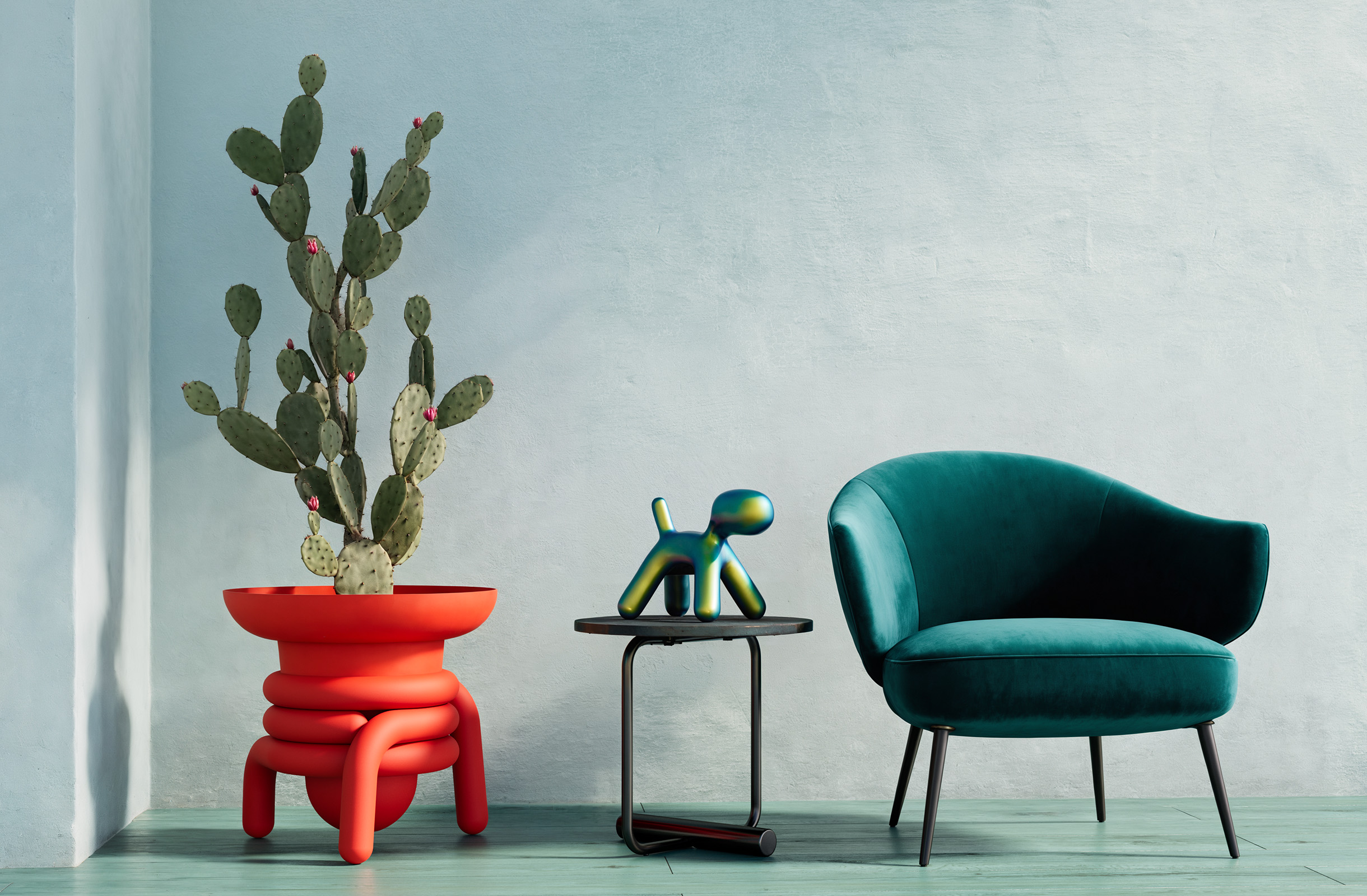 Red Jill with a cactus beside a green chair in a pale turquoise interior