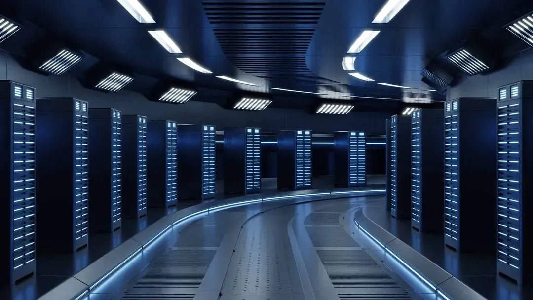 Futuristic data center corridor lined with illuminated server racks, featuring sleek, blue lighting and a curved walkway.