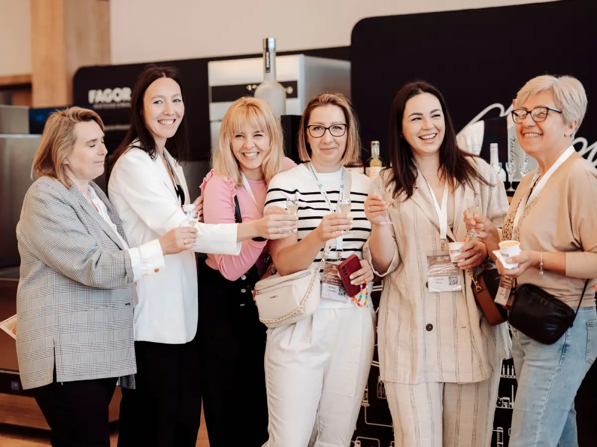 Uśmiechnięci uczestnicy targów Gastronet z torbami konferencyjnymi – atmosfera wydarzenia.