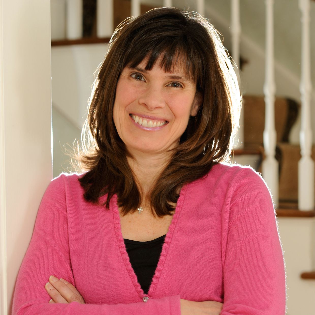 Carol McCarthy, MS, FMCHC in a pink sweater arms folded and smiling