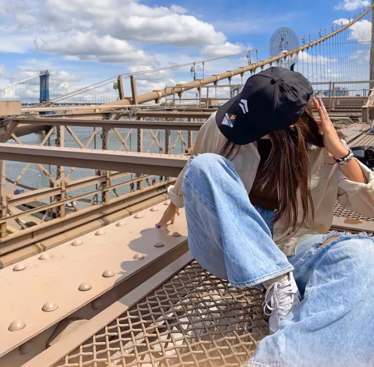 A woman sit on an edge of a bridge