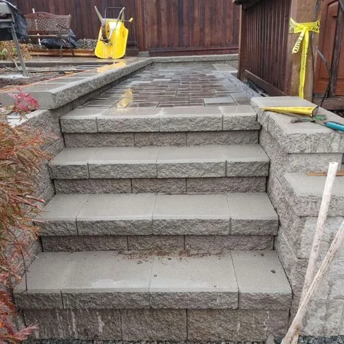 Freshly built concrete block steps and paver landing in backyard renovation