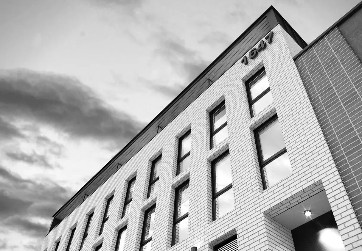 The building is defined by its white-brick exterior, with black steel accents and tall windows that draw natural light inside.
