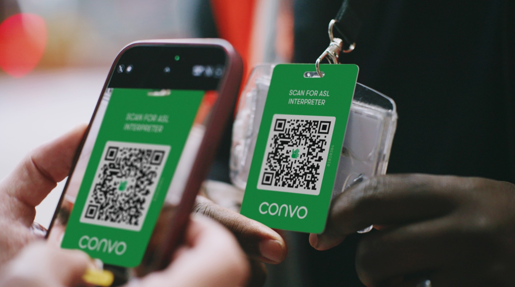Hand holding Convo Access QR badge for ASL interpreter