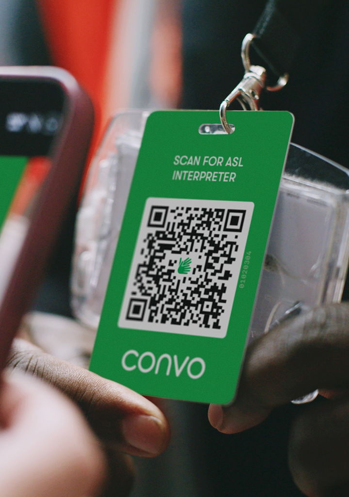 Hand holding Convo Access QR badge for ASL interpreter
