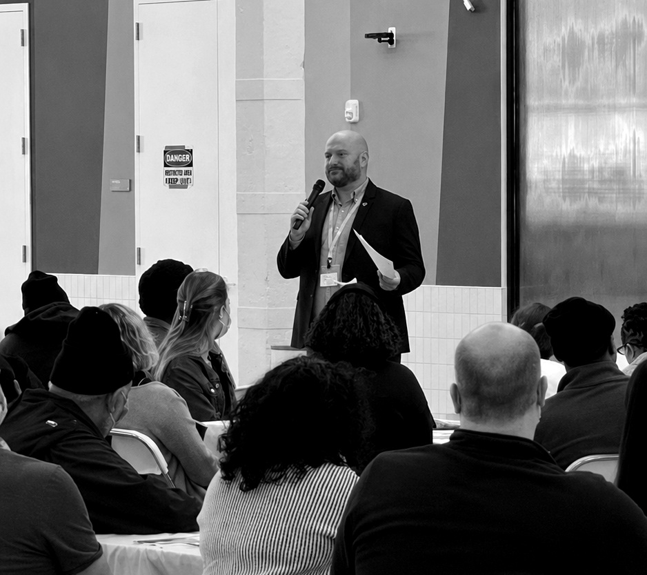 Andrew speaking with organizational leaders and community members at a town hall.