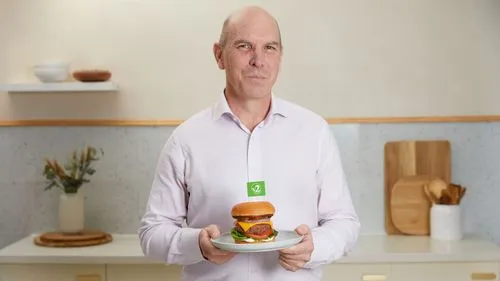 A photo of Tim York, the CEO, holding a v2 burger.