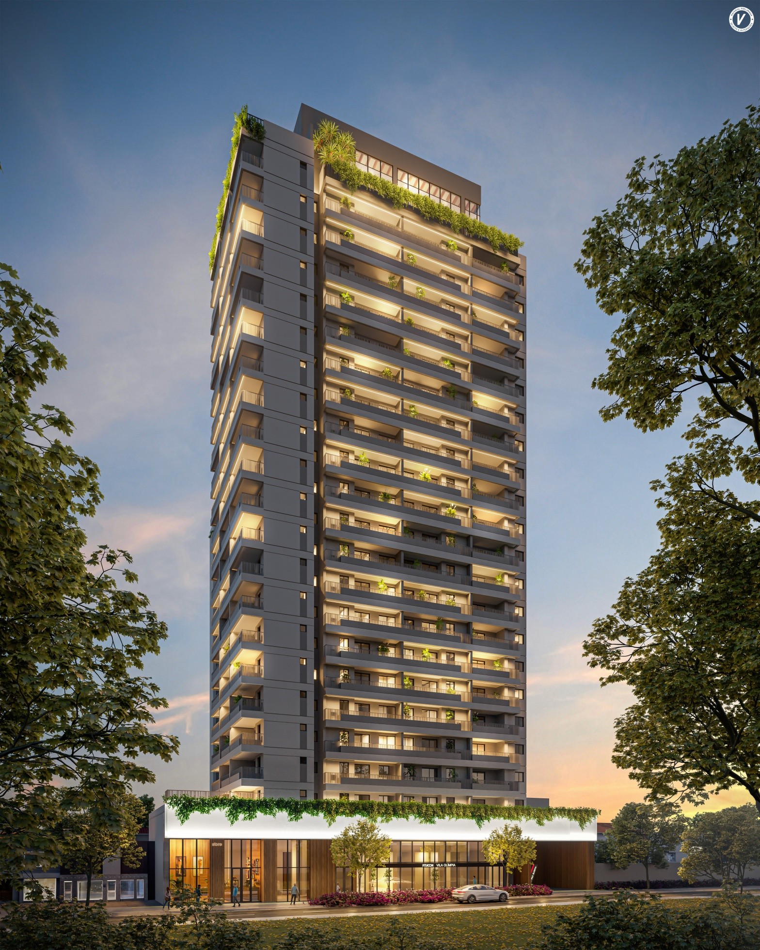 Tall modern apartment building illuminated at dusk with other buildings and trees under a cloudy sky.
