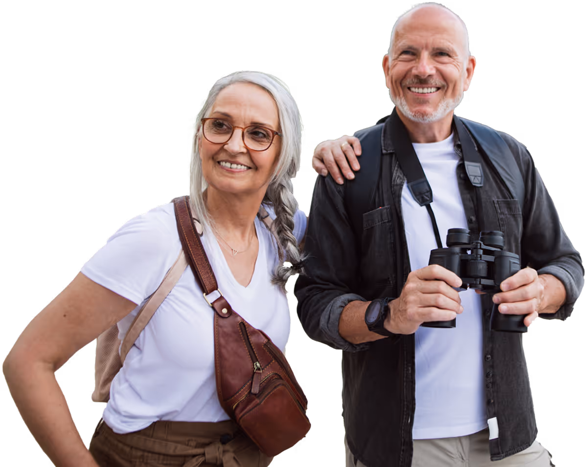 A cheerful older man and woman with grey hair smiling and looking off-camera against a plain white background.
