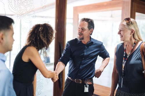 Three people networking at an Impact North event.