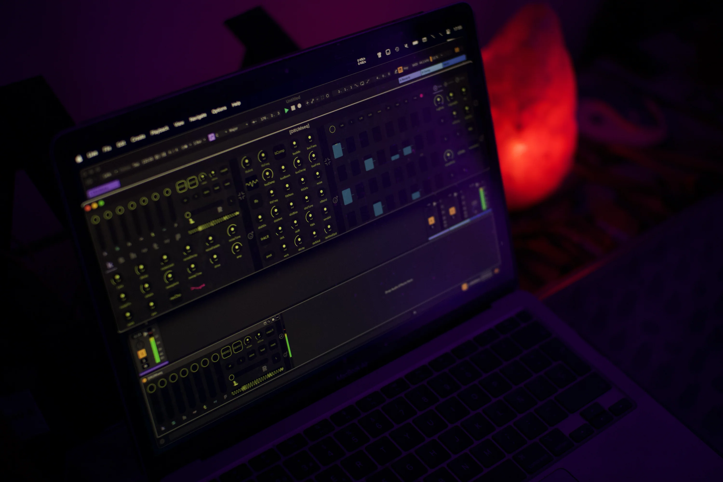 DRUMseq Max for Live device in an electronic music studio. The step sequencer, stereo effects chain and channel faders are visible