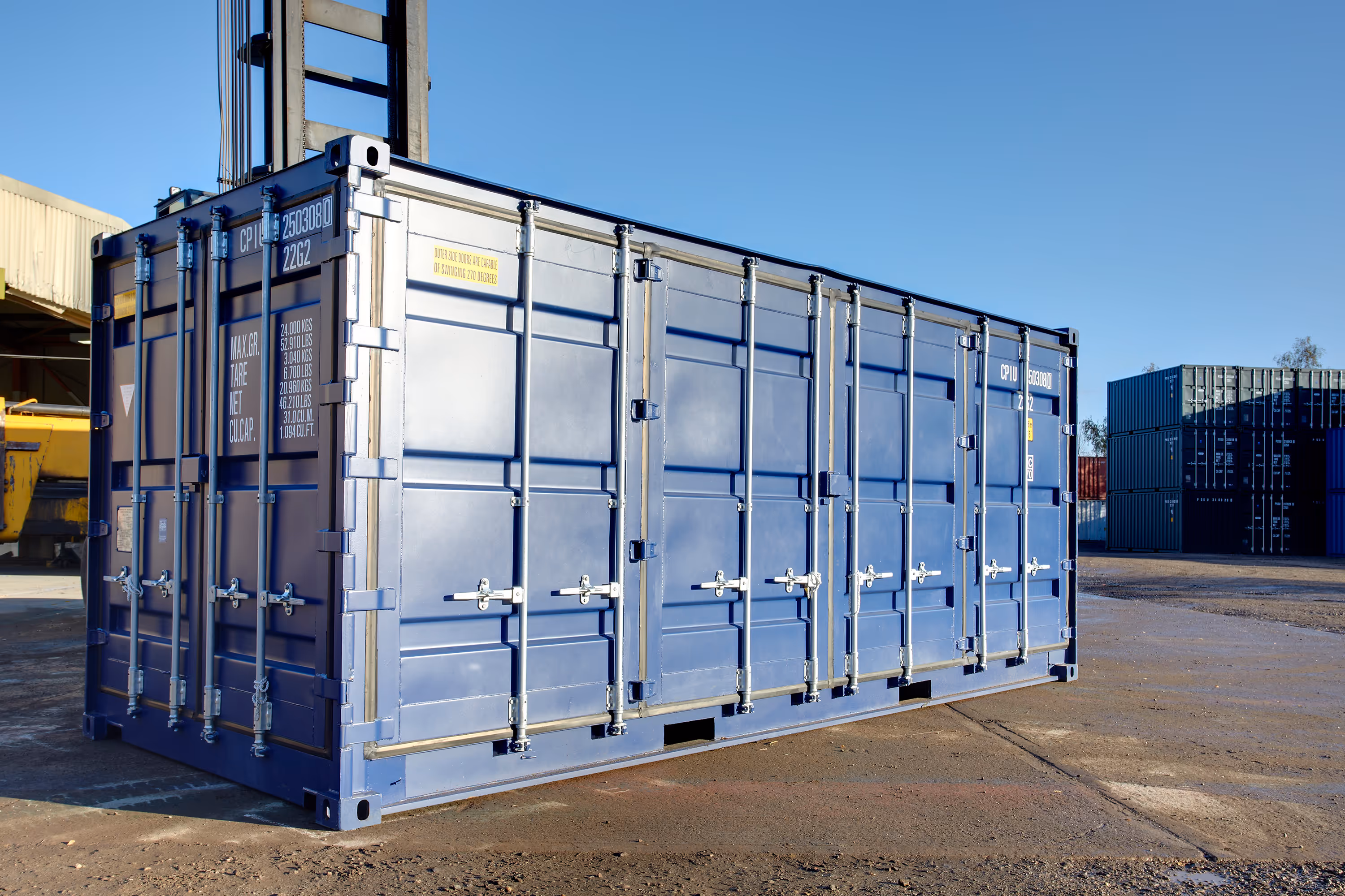 A blue shipping container is parked outside.