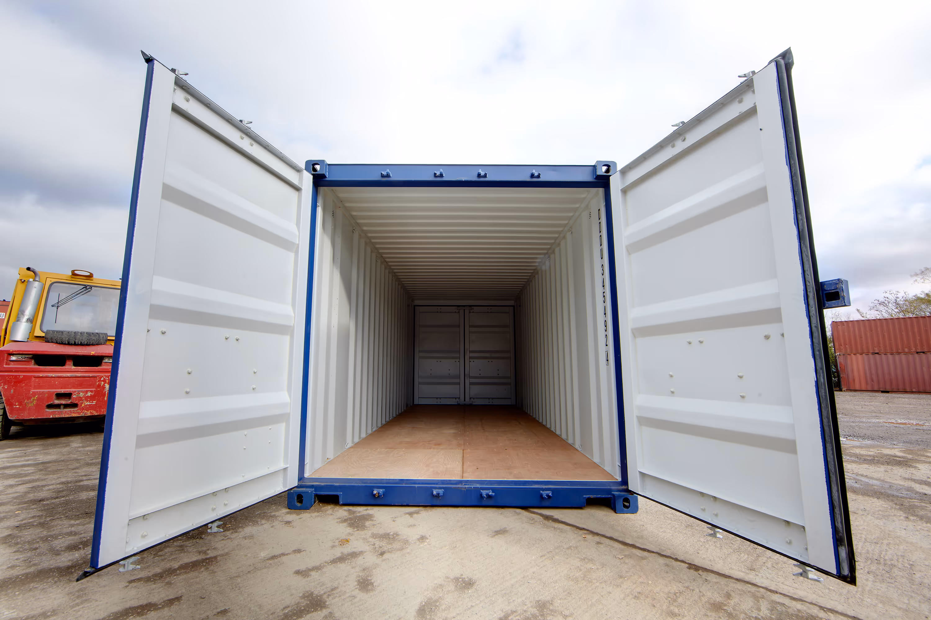 A white shipping container with a blue door.