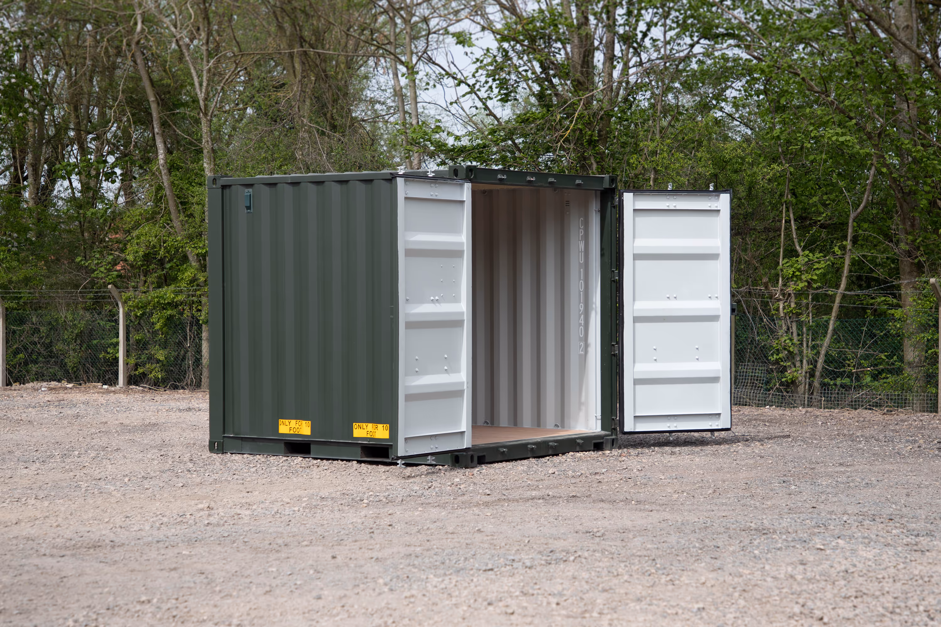 A green shipping container with a white door.