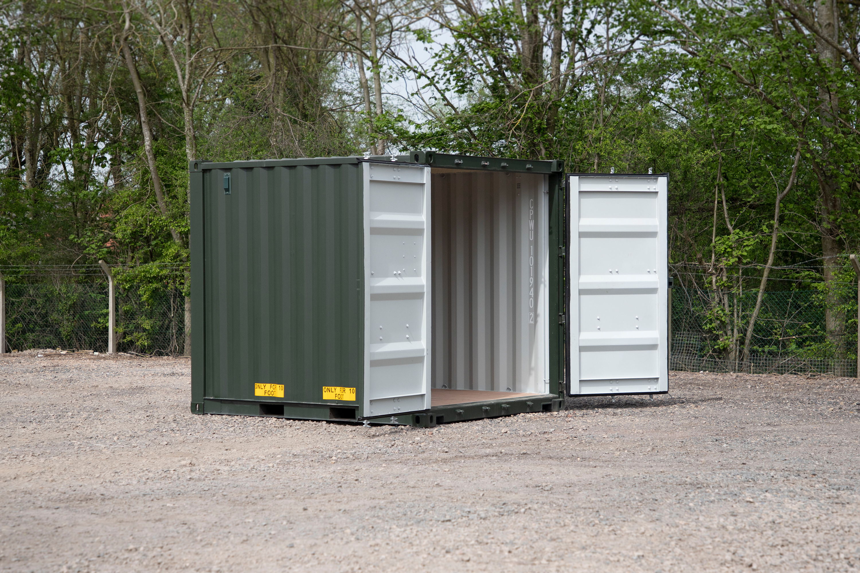 A green shipping container with a white door.