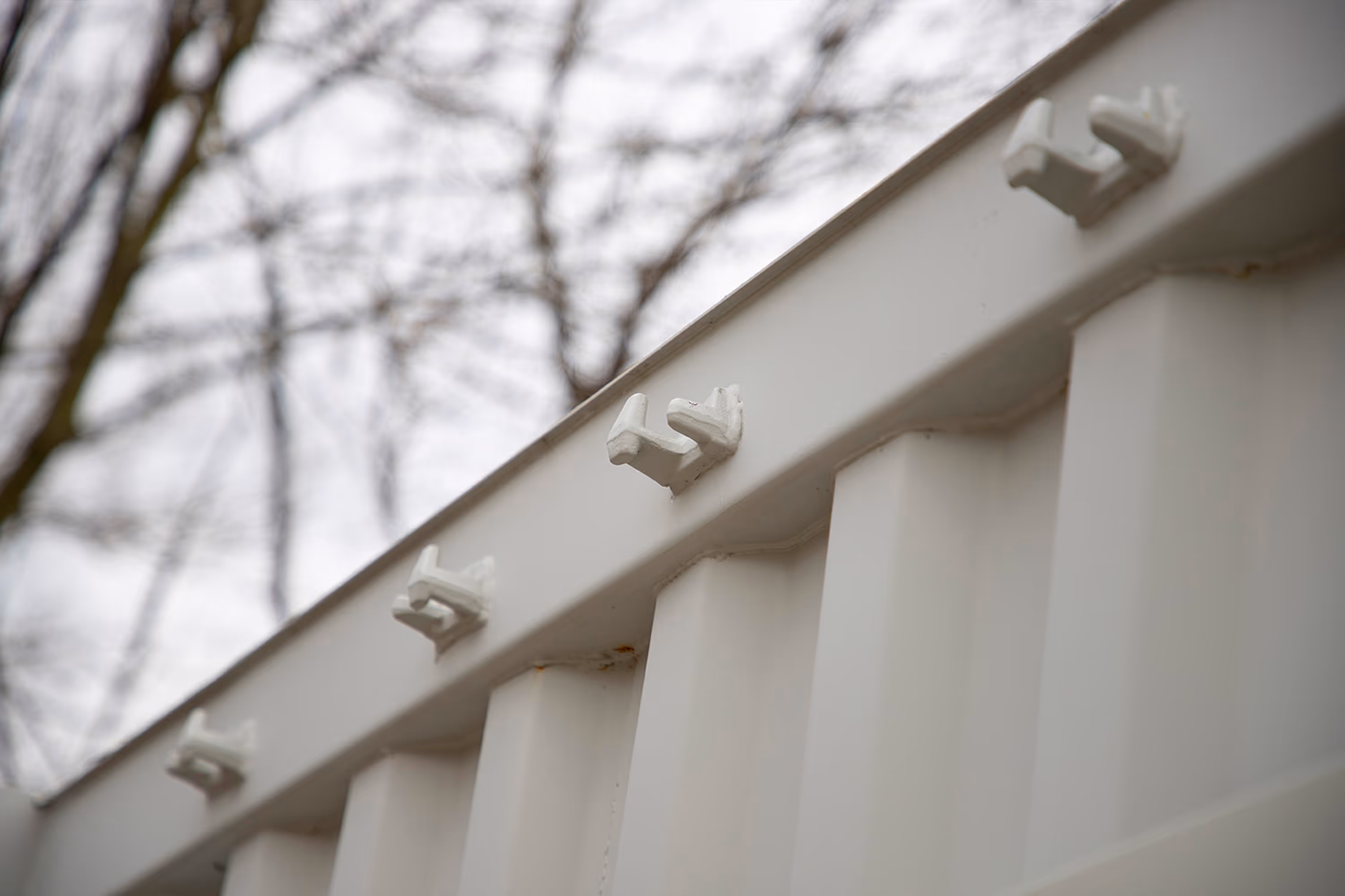 A white metal shipping container roof with white metal pieces on it.