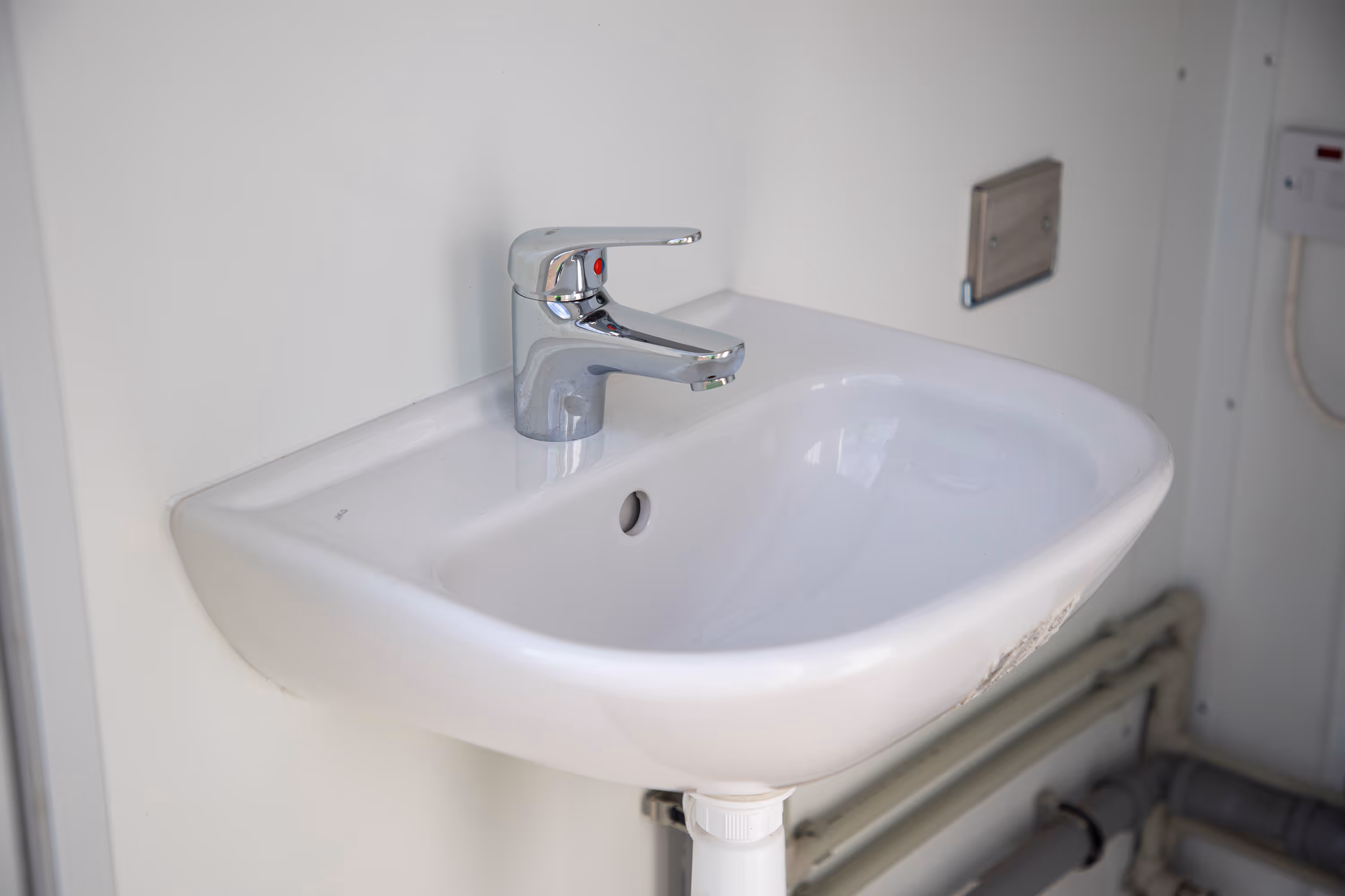 A white sink with a silver faucet.
