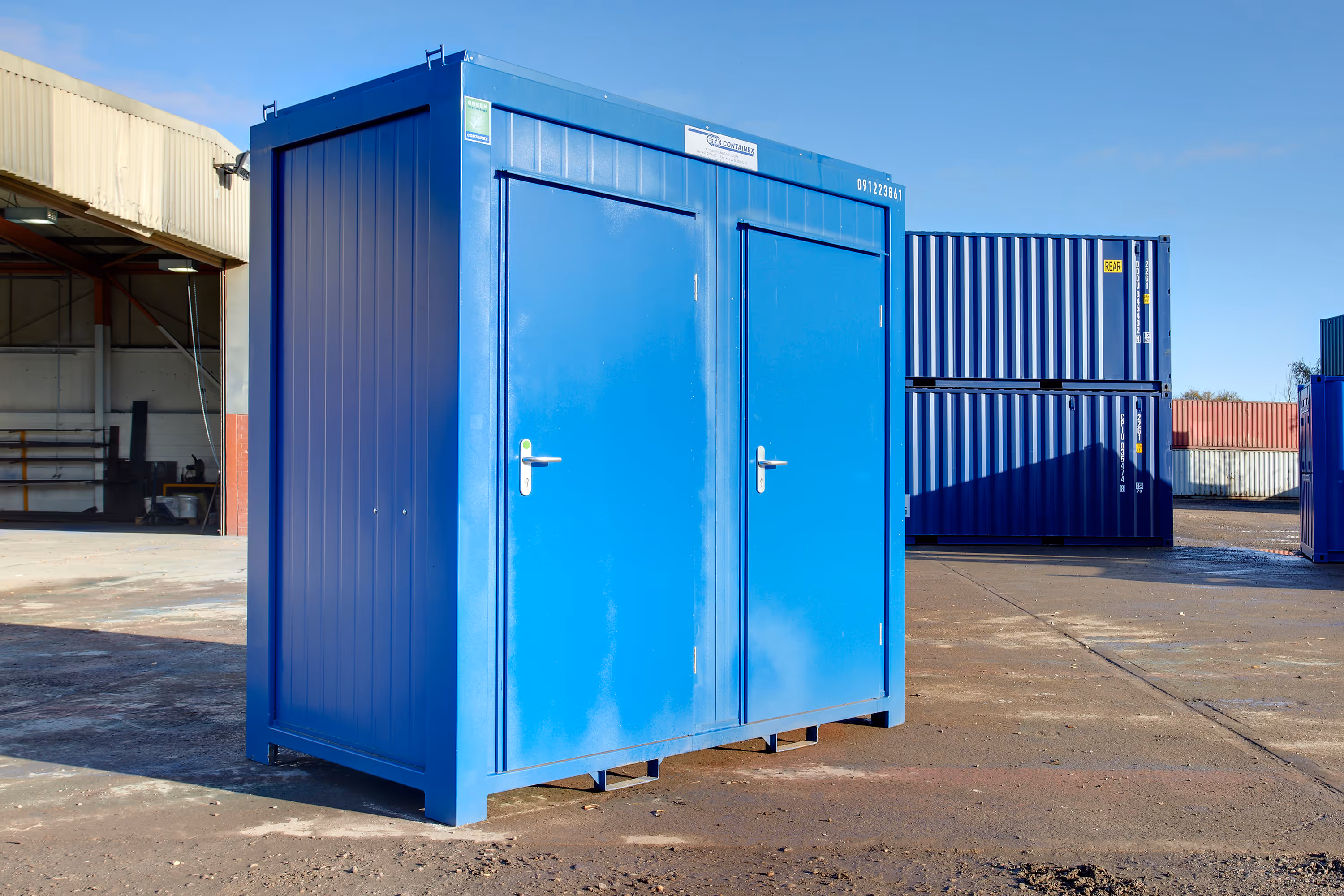 A blue portable bathroom with two toilets.