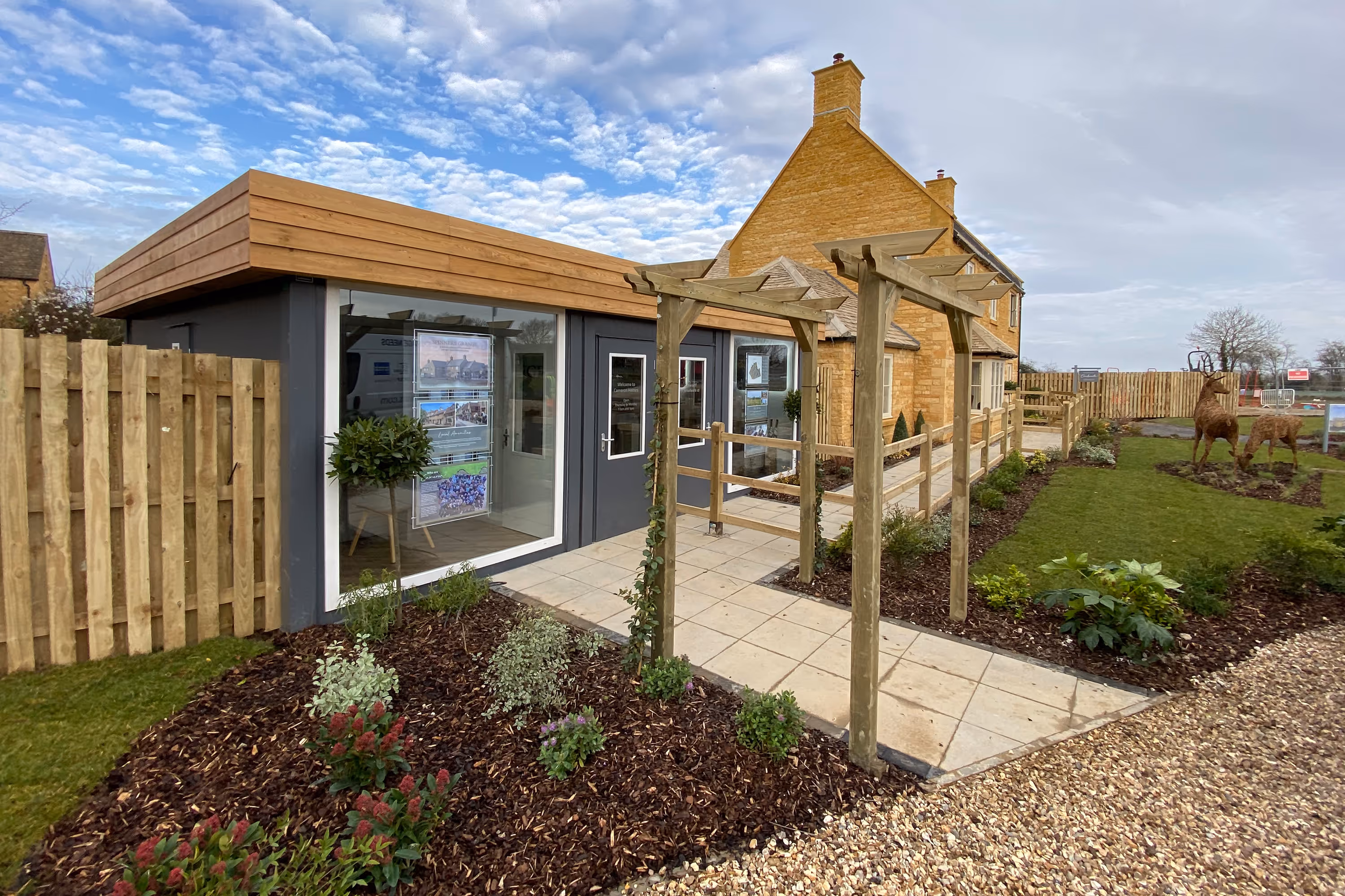 A house from a shipping container with a wooden deck and a brick patio.