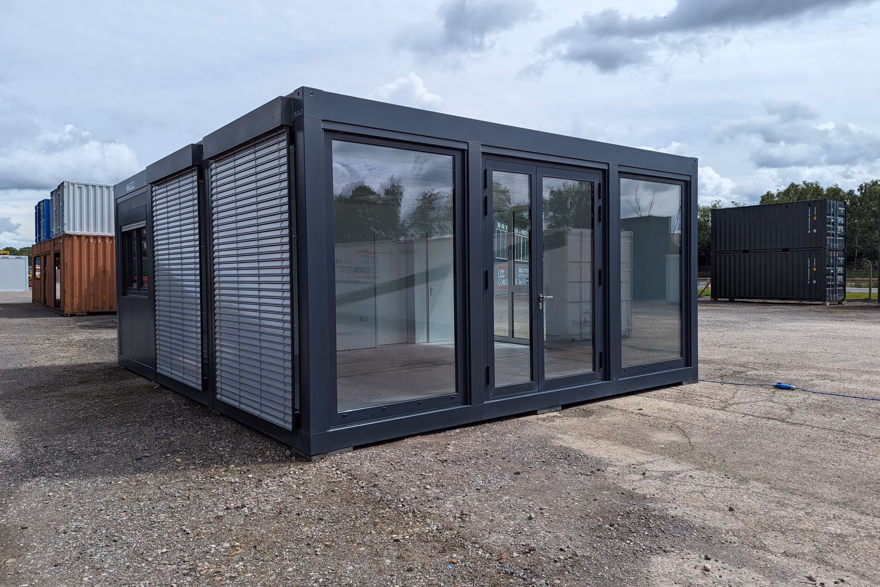 A small grey building with a lot of windows.
