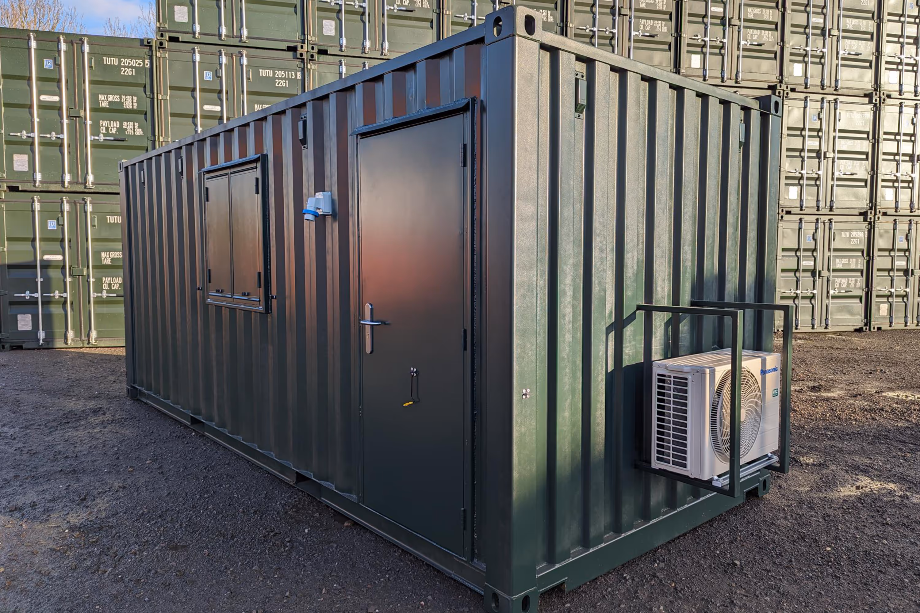 A green shipping container with a white fan inside.