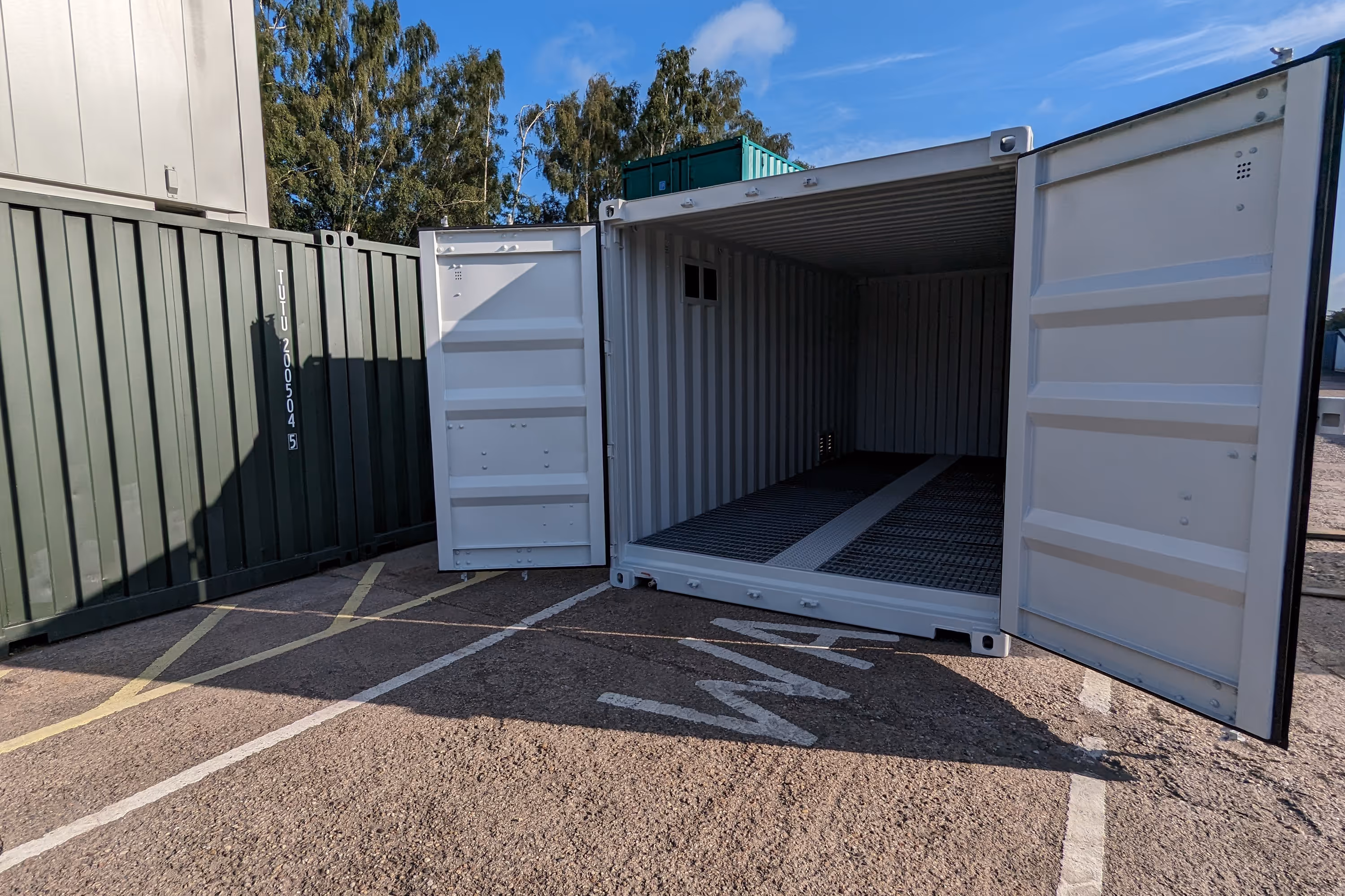 A white shipping container with a black door.
