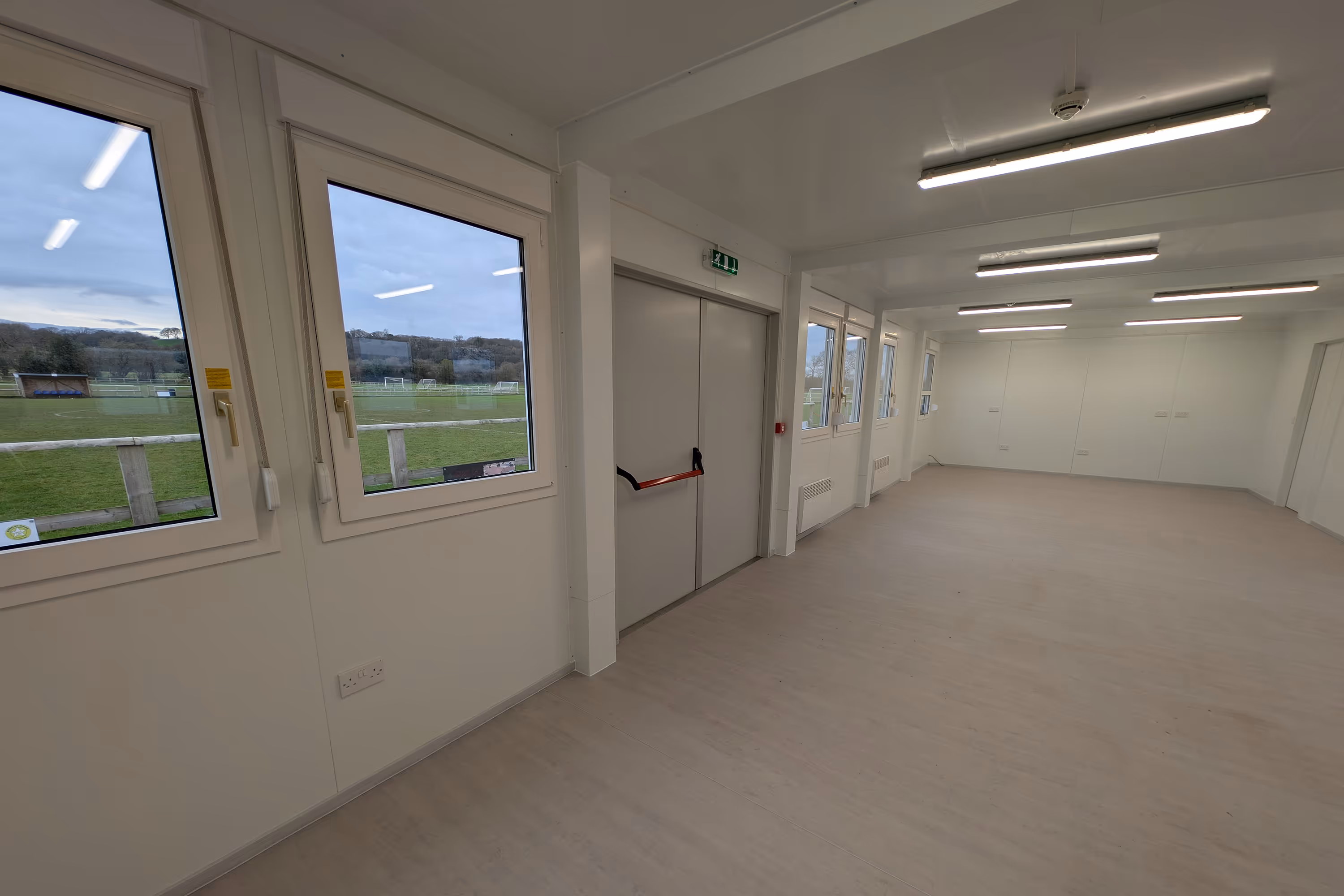 A large white room with a door and a window.