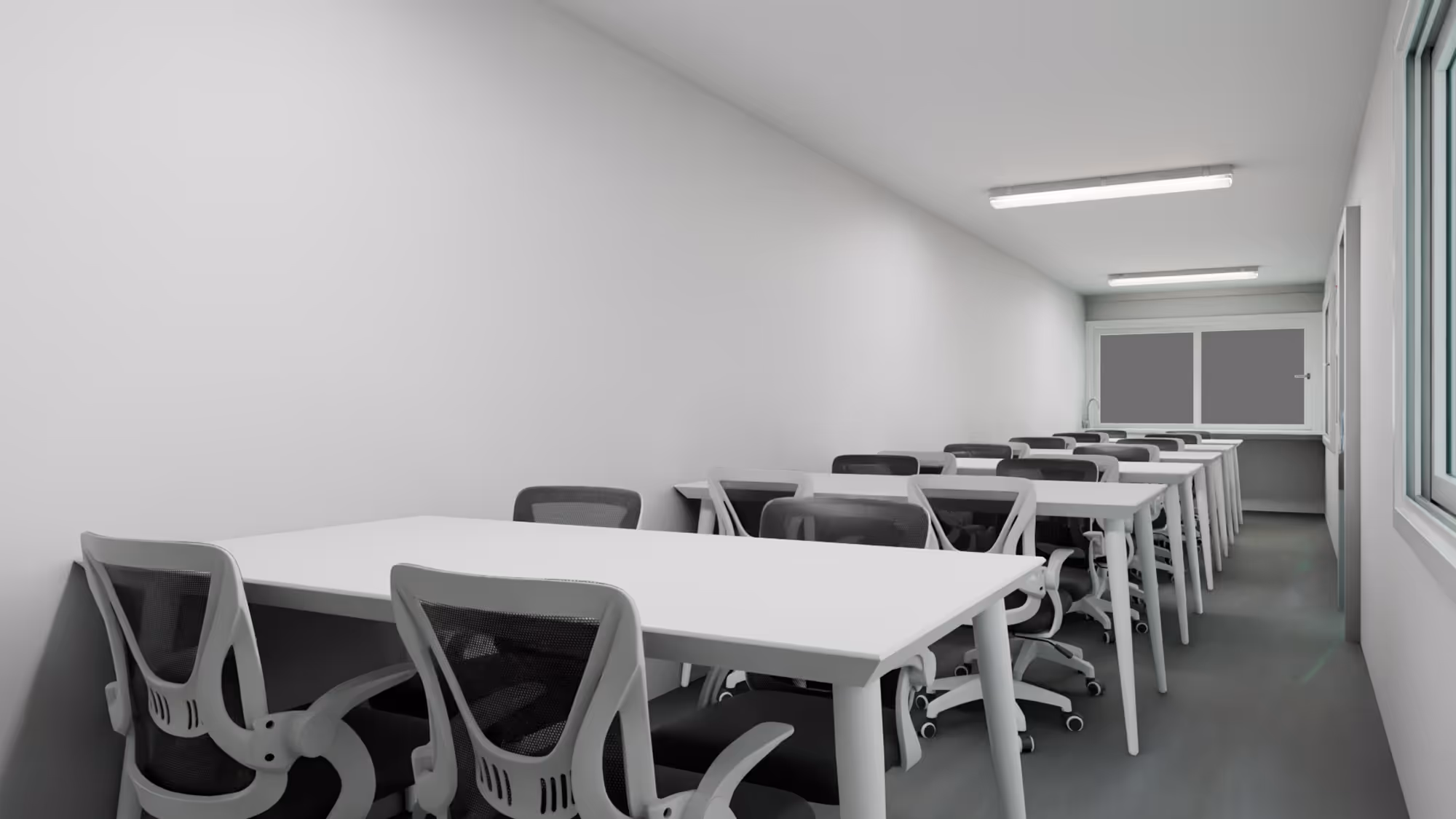 Minimalist classroom with rows of white desks and black mesh office chairs under fluorescent ceiling lights.