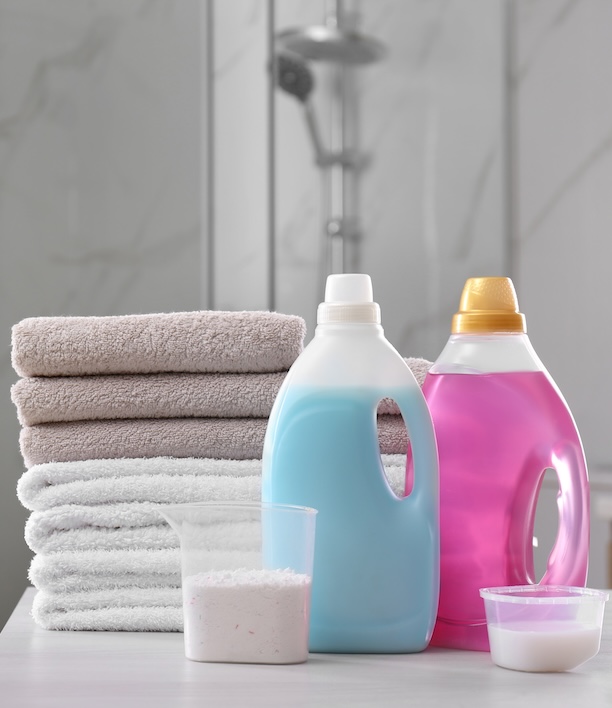 Laundry detergent and supplies arranged on a shelf, representing the everyday costs of doing laundry that this guide puts into context against the cost of a wash and fold service