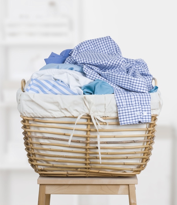 Overflowing laundry basket sitting ready for pickup, representing the straightforward handoff this guide walks you through from start to finish