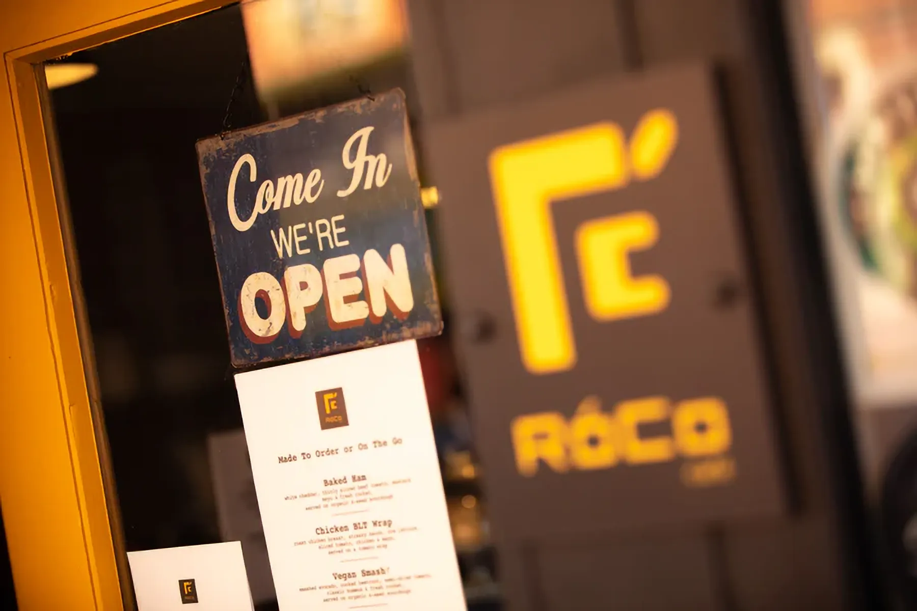 A sign on the entrance doors saying the café is open