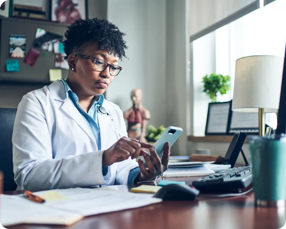 Medical professional interacting with the epocrates application on a mobile device, focused on patient care.