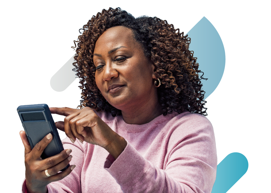 Smiling clinician in a pink sweater looking at her smartphone