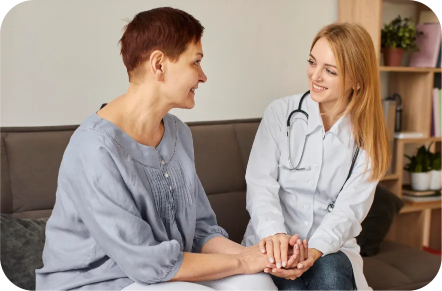 A healthcare provider talks with a patient, offering reassurance and recovery support services in a calm environment.