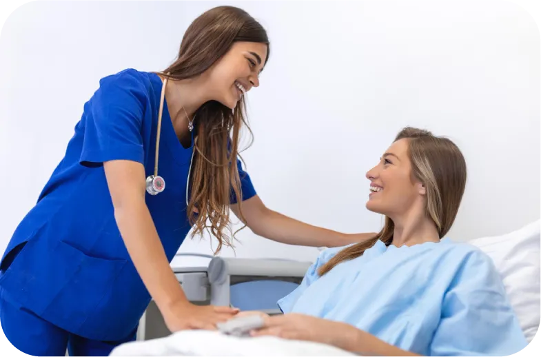 A nurse in blue scrubs provides personalized care and support to a smiling patient resting in a hospital bed.