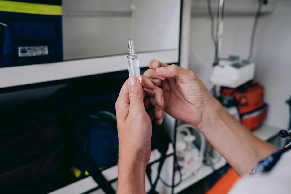Hands holding a medical vial in an indoor setting, focused on healthcare or medical theme.