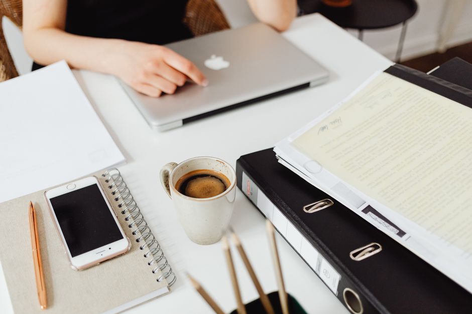 A clean workspace featuring a laptop, coffee, smartphone, and documents for efficient work.