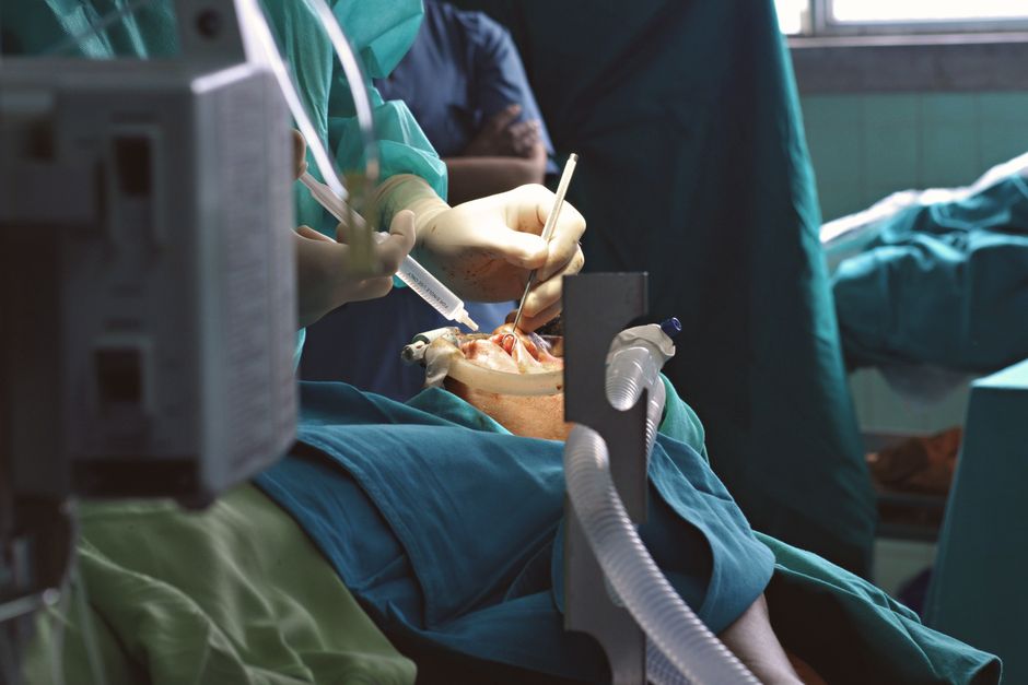 A detailed view of surgeons operating in a sterile environment, showcasing medical equipment and precision.