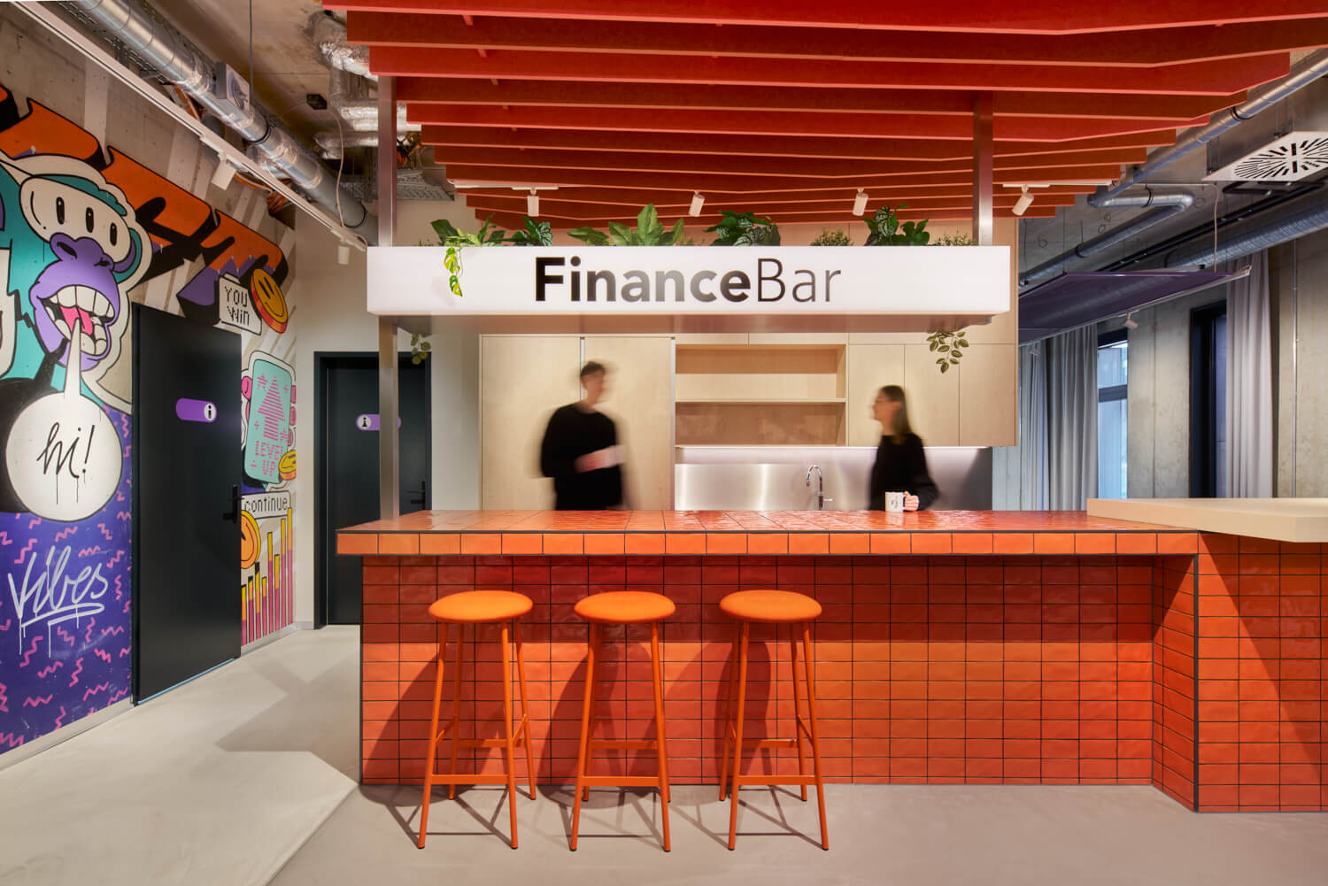 Moderne „FinanceBar" mit orangefarbener Kacheltheke, roten Barhockern und buntem Graffiti-Wandbild in einem jugendlich gestalteten Bankberatungsraum.