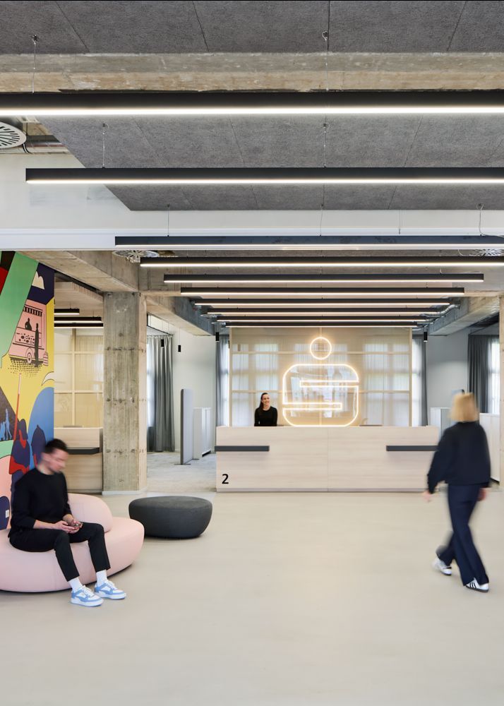 Ein Empfangstresen aus Holz und warme Rottöne heißen die Besucher der Stadtsparkasse Düsseldorf Willkommen | Bank Architekt bkp