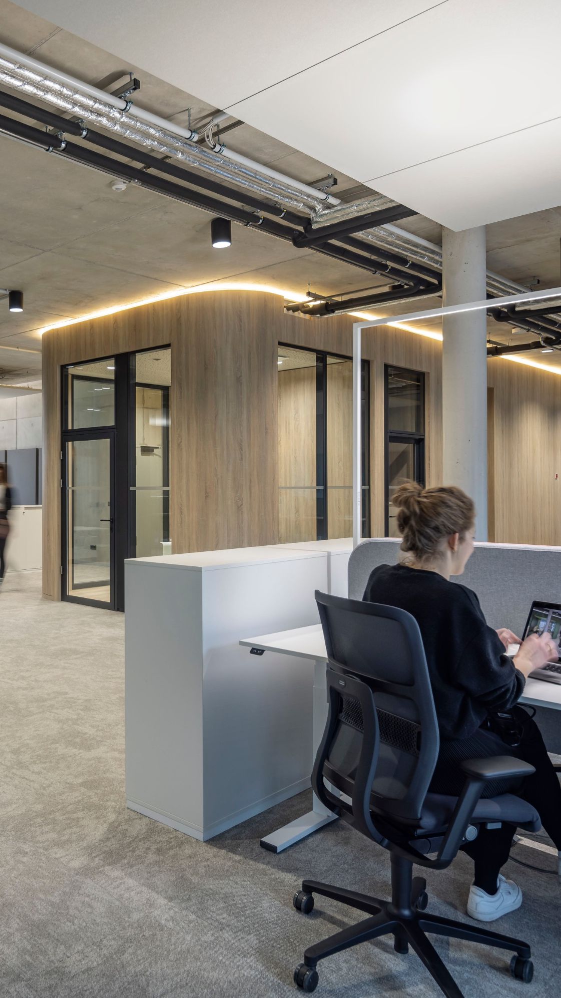 Open Space Büro Konzept mit geschlossenen Räumen für kommunikativen Austausch.
