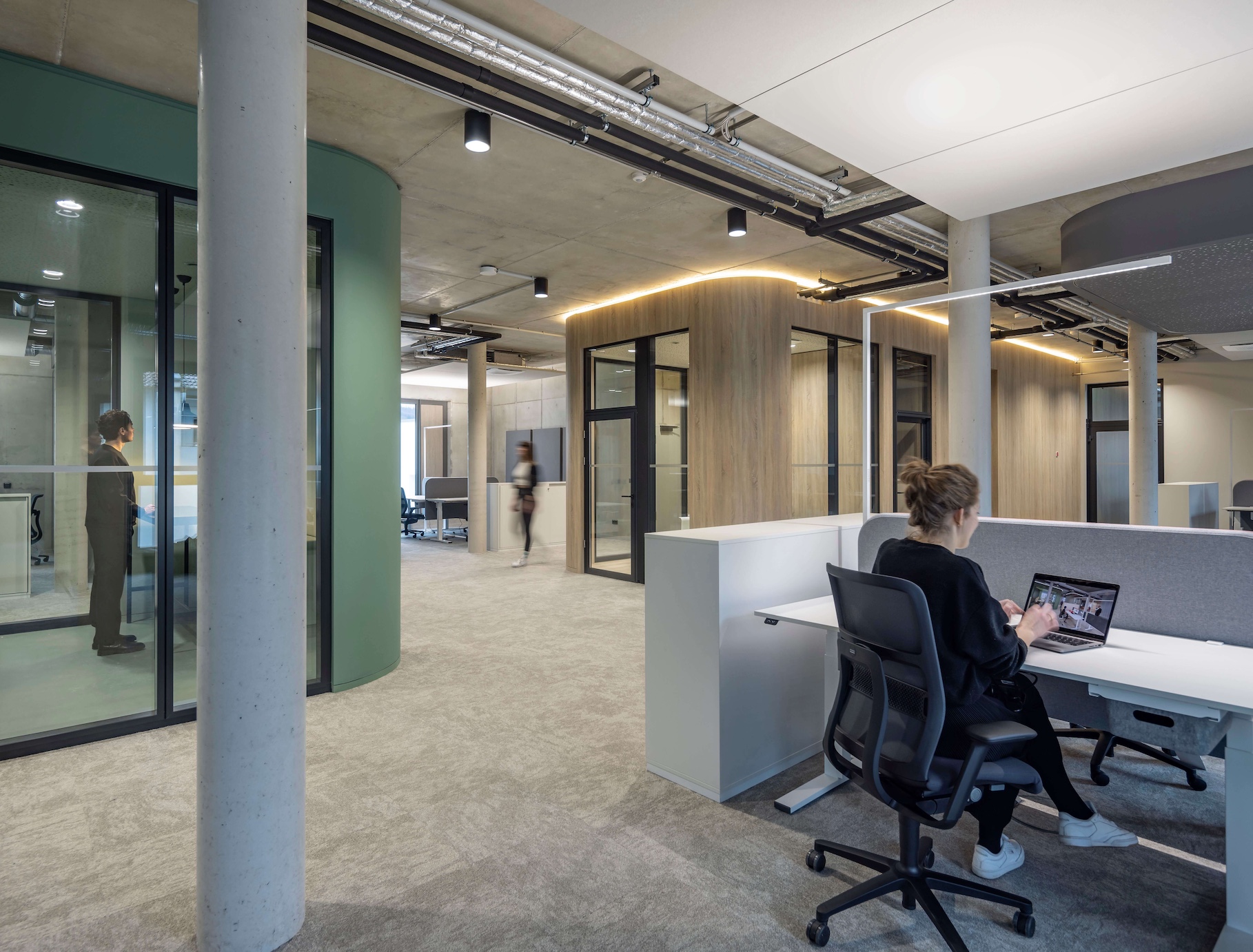 Open Space Büro Konzept mit geschlossenen Räumen für kommunikativen Austausch.