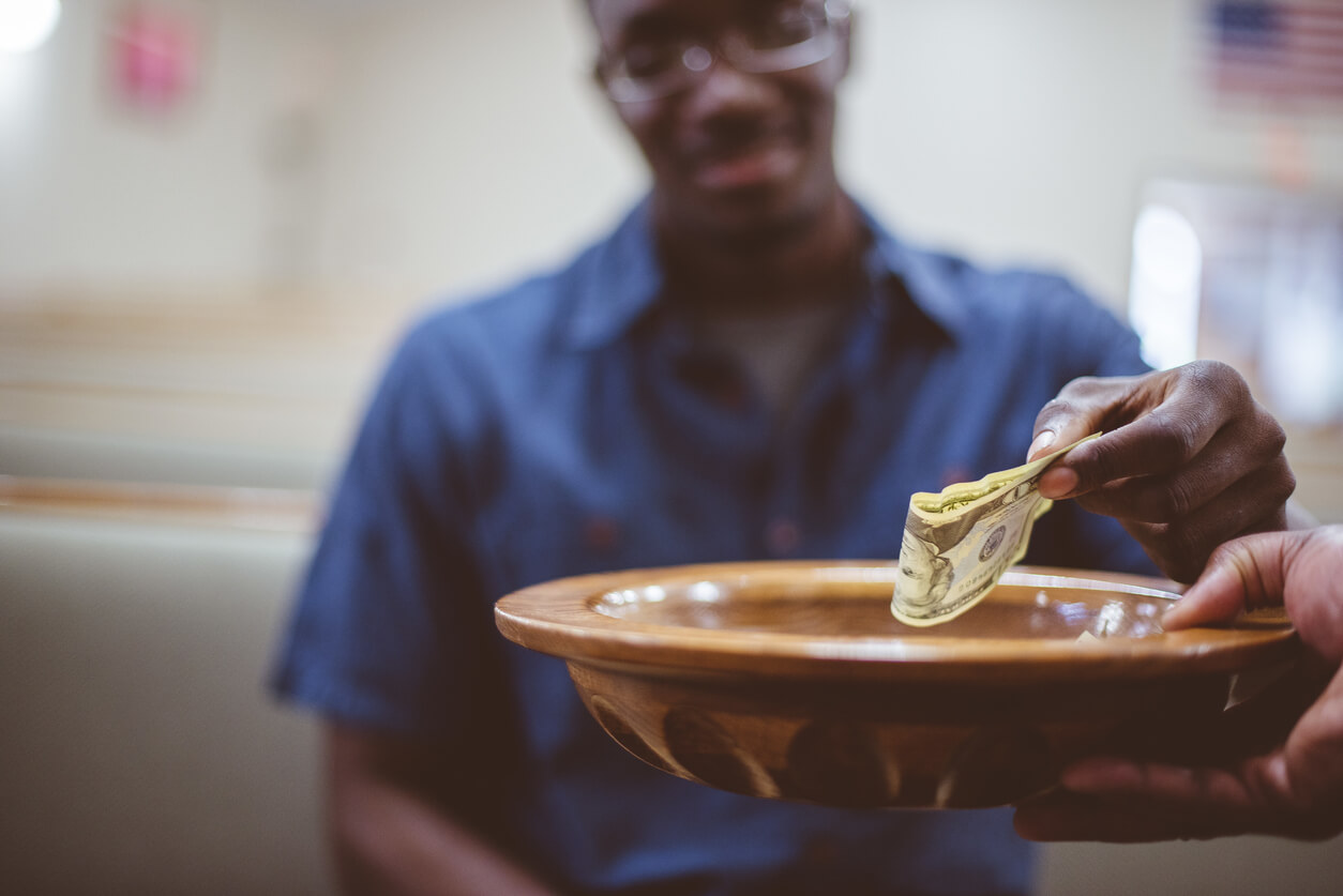 An African American man donates a tithe