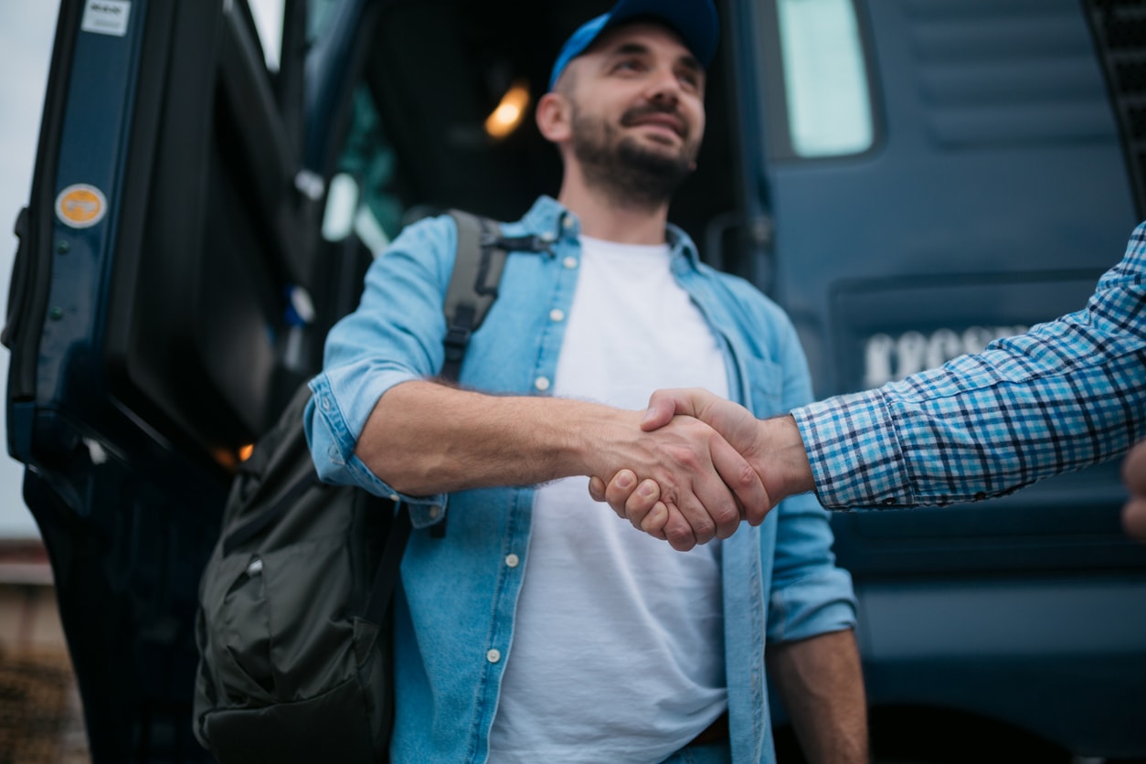 A photo of two men shaking hands and smiling.