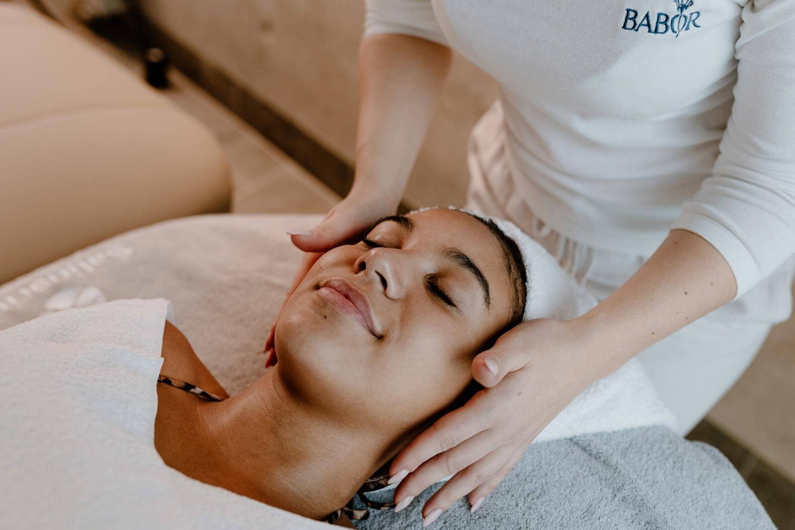 Frau entspannt mit geschlossenen Augen während einer Gesichtsmassage im Wellness-Bereich der Salinarium Bad Dürkheim Therme