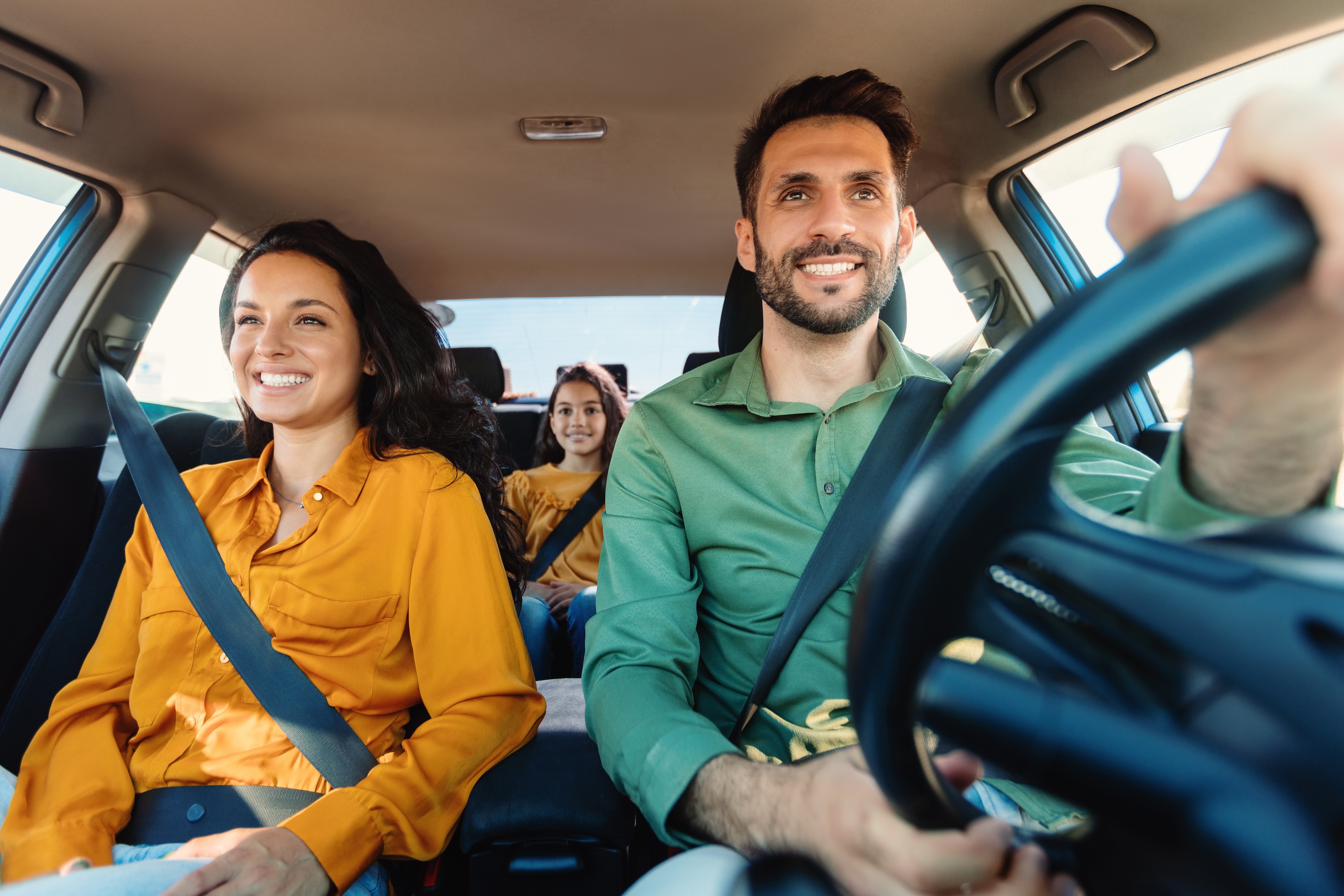 A happy family smiling and enjoying a drive in their car, representing the convenient and family-friendly lifestyle at Wildcat Vista in Godley, TX.