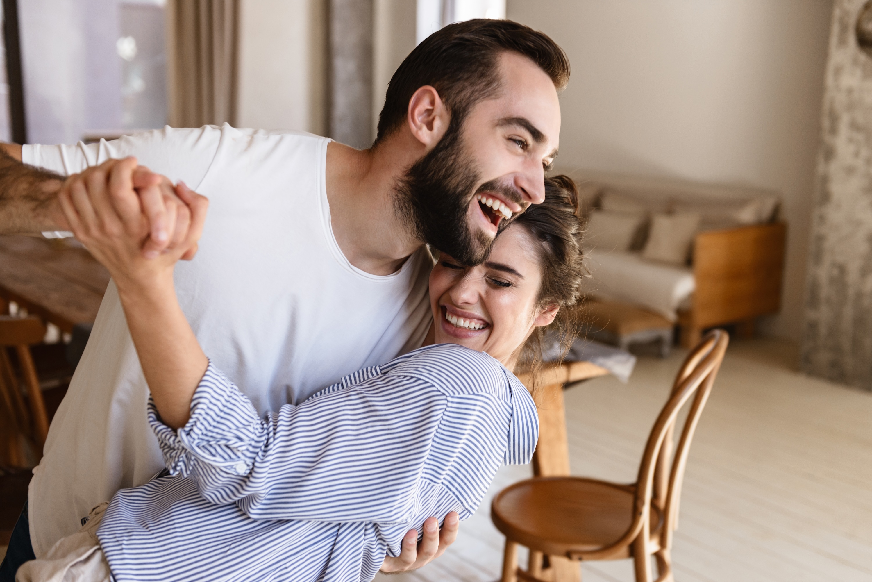 Smiling couple dancing together in a brightly lit, modern living room at Wildcat Vista.
